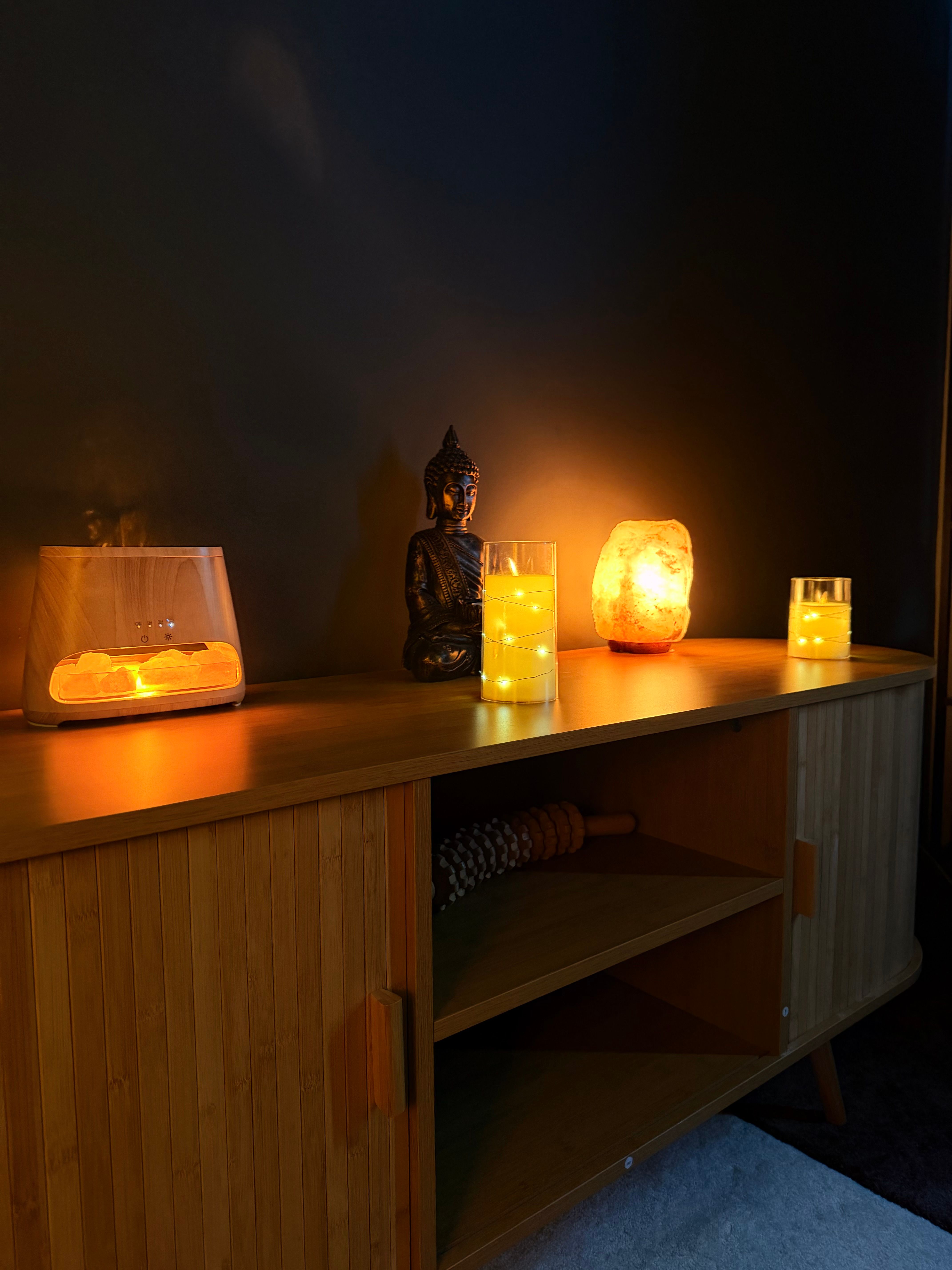 Difusor de aromaterapia, velas y una lámpara de sal sobre la cómoda de la cabina